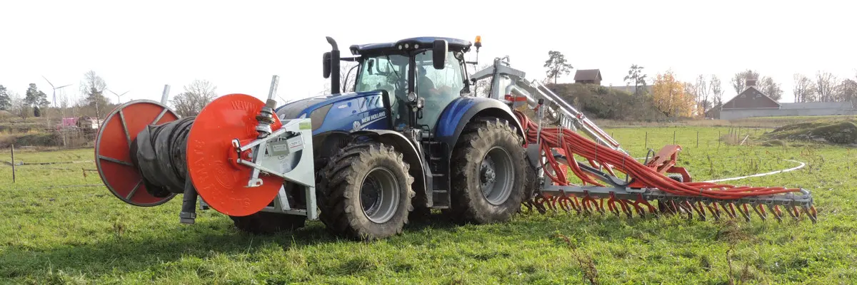 Traktor och släpslangsspridare med gåsfot