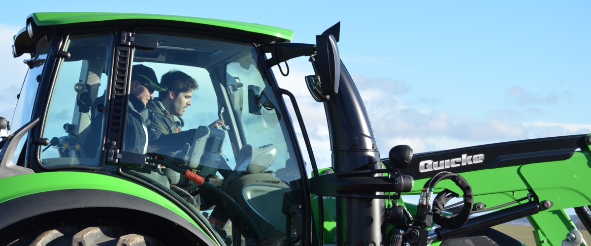 Lantbrukare kör traktor tillsammans med rådgivare