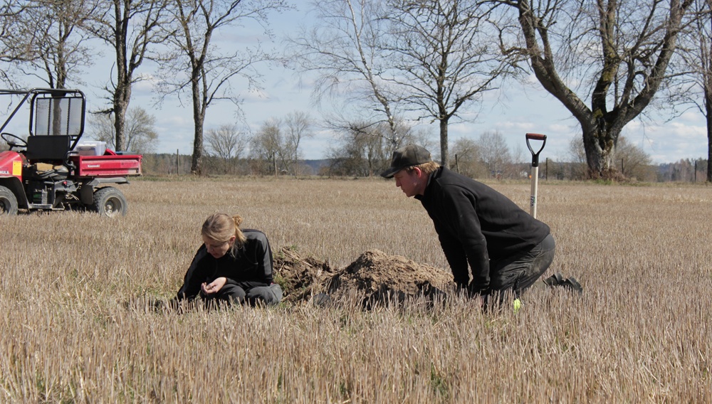 två personer sitter på ett fält