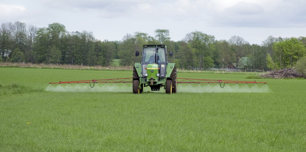 traktor med växtskyddspruta på fält