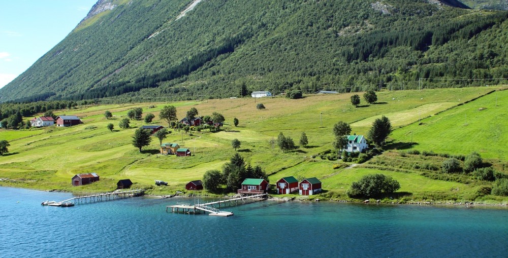 vatten och ängar med fjäll i bakgrunden