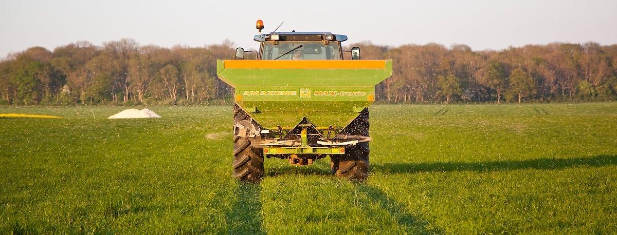 Traktor med handelsgödselspridare