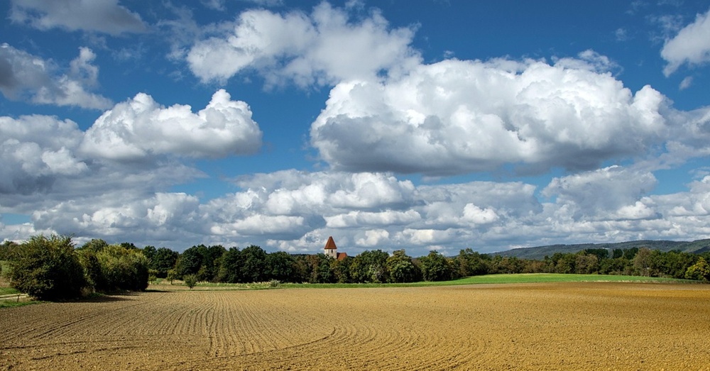åker med kyrka i bakgrunden