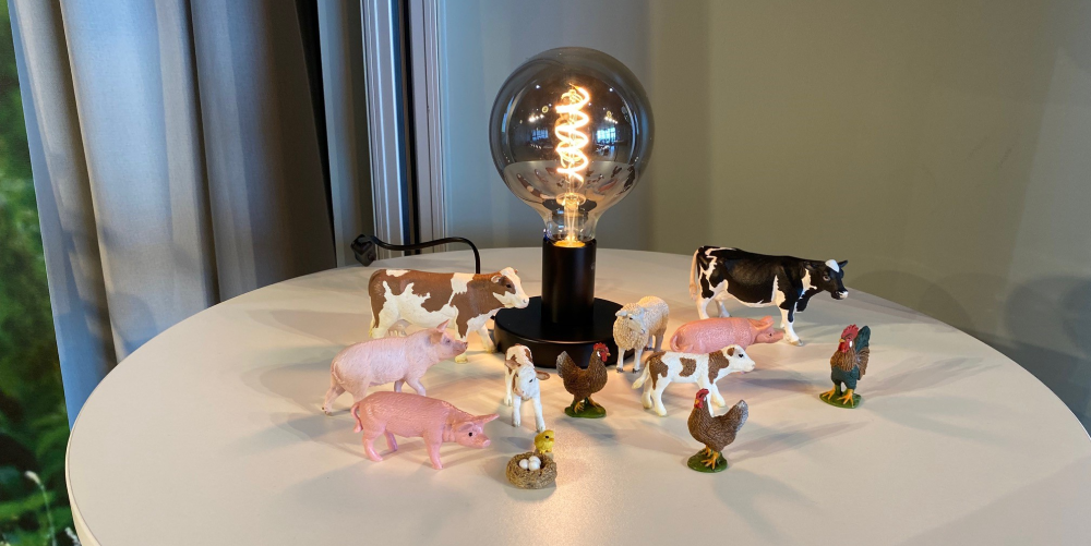 Lampa på bord omringad av plastdjur